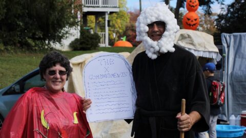 A church couple dressed as Moses holding the 10 Commandments and the burning bush